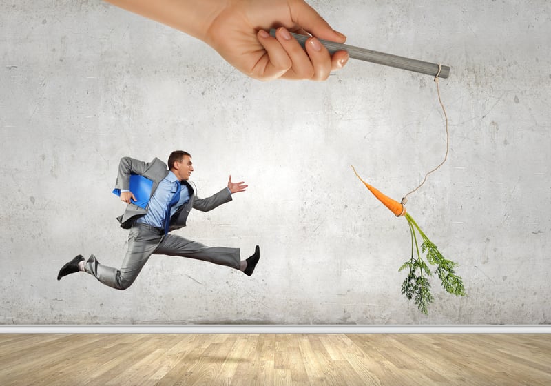 Funny image of businessman chased with carrot