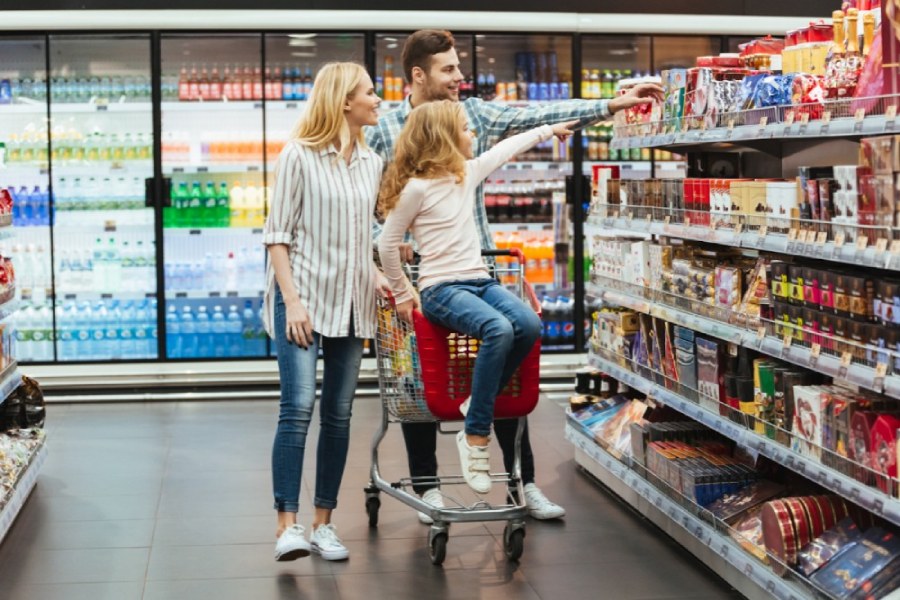 Happy family looking at product in a grocery store. Customers buying food at the market.