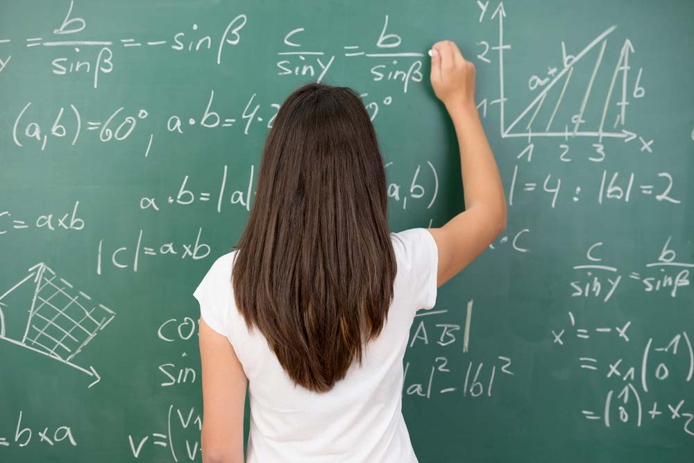 young-woman-solving-equation-at-chalkboard