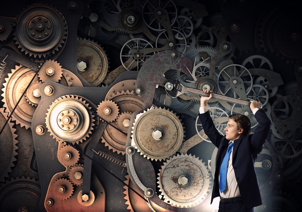 Young businessman fixing gears mechanism with wrench-1